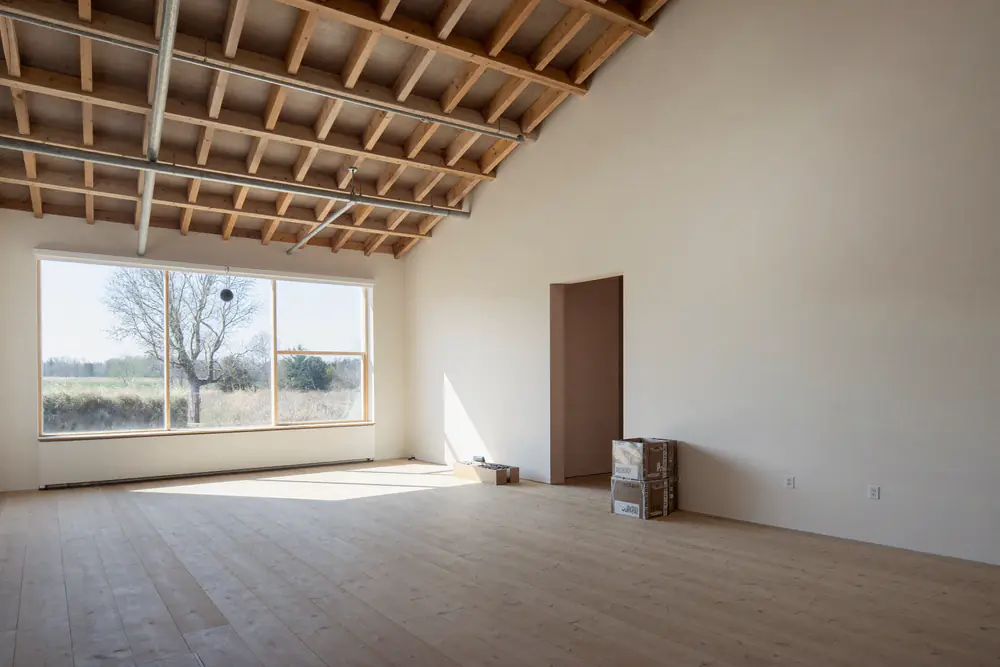 Ruime zolderverdieping met hoog plafond en een glazen wand over de hele breedte