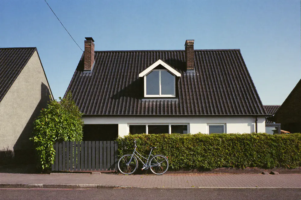 Voorzijde van een rijwoning uit de jaren tachtig met een dakkapel aan de straatkant